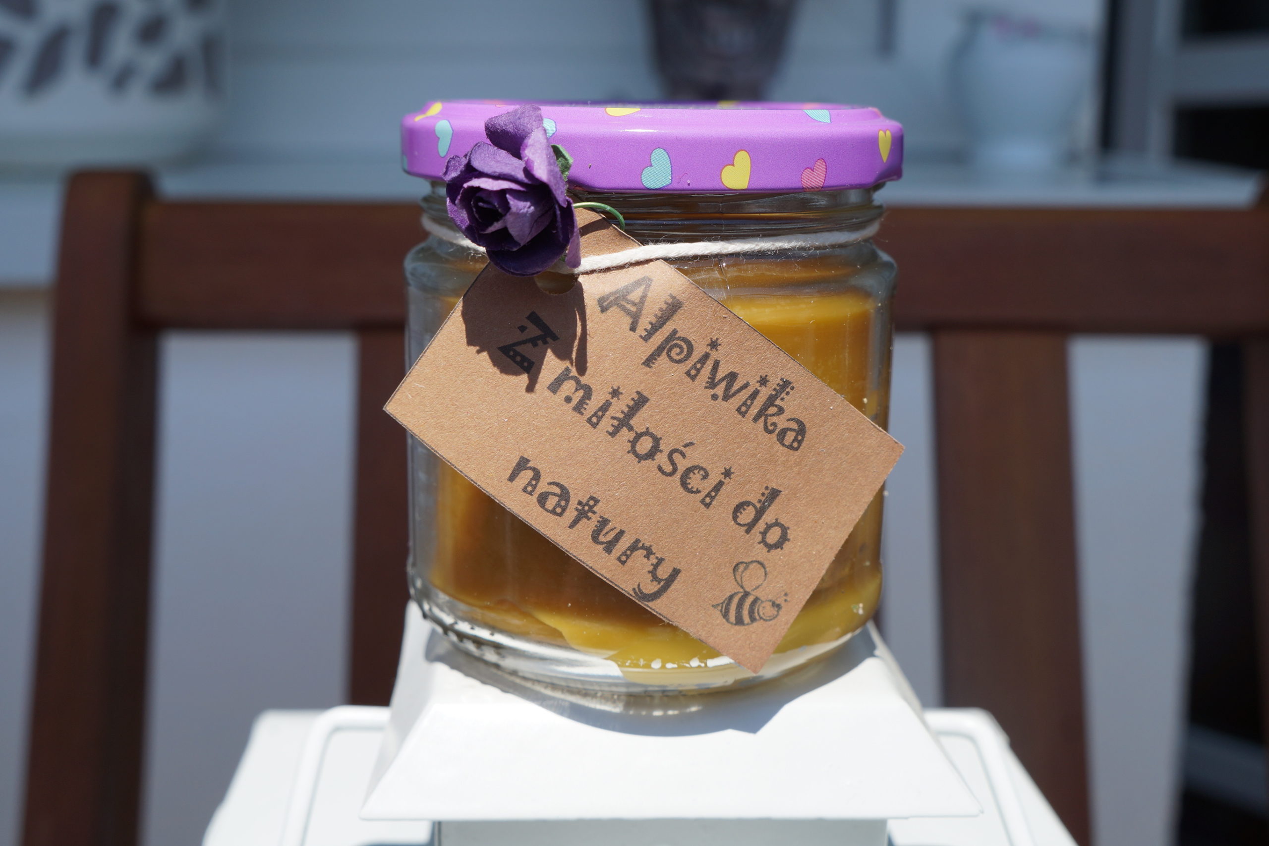 Świeca z naturalnego wosku pszczelego w słoiku z etykietą
