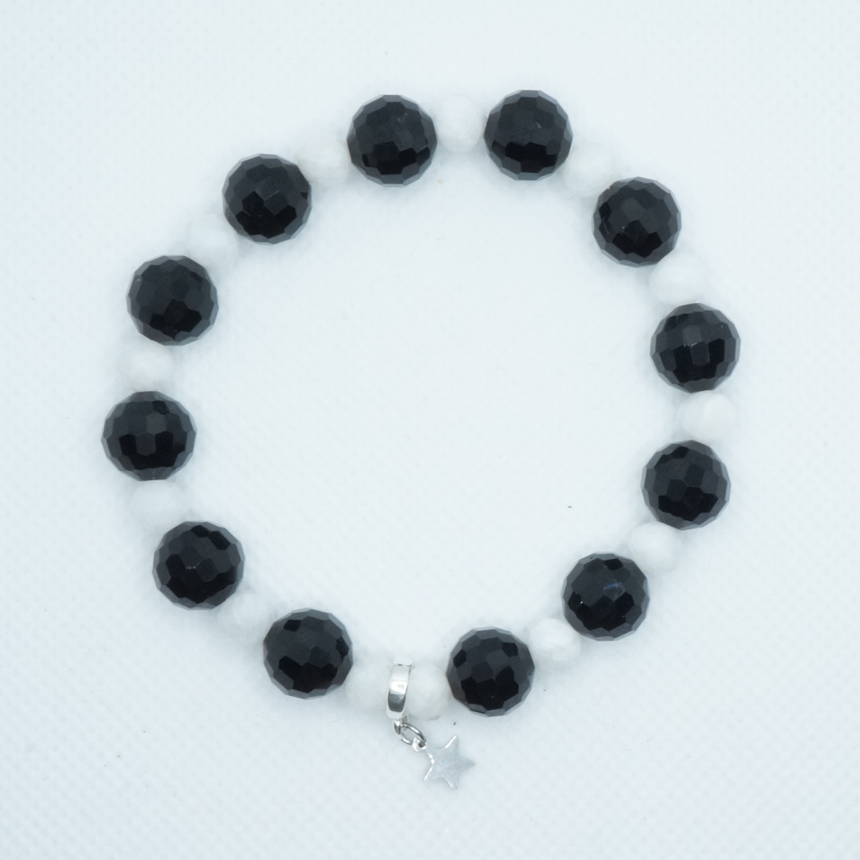 Bransoletka z kryształu czarnego i białym kamieniem księżycowym z zawieszką w kształcie gwiazdki ze stali chirurgicznej.